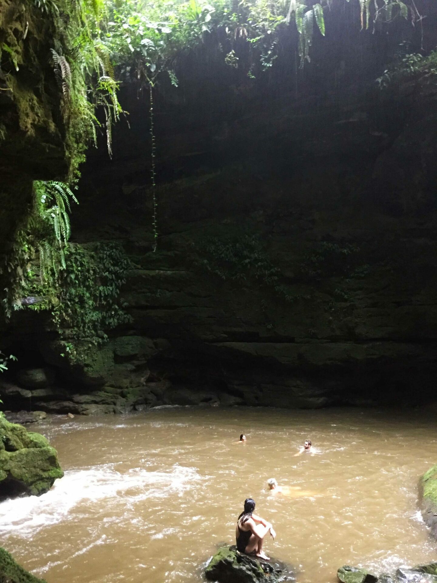 Resting during an intense hike into a canyon in the Amazon Rainforest Julia in a canyon waterfall in Tena, Ecuador
