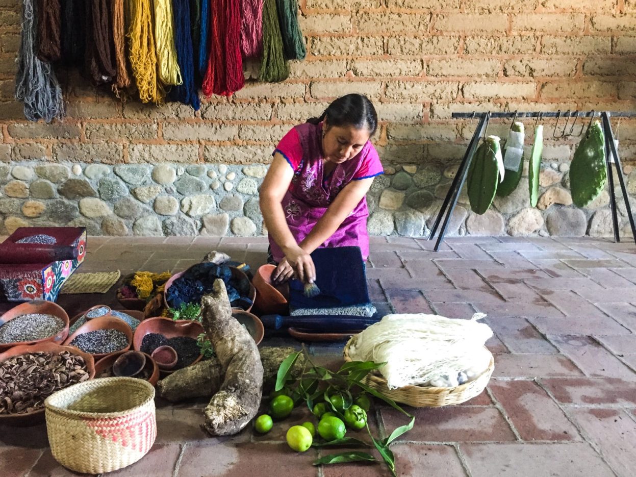 Grinding indigo on a traditional stone metate. tour oaxaca las bugambilias