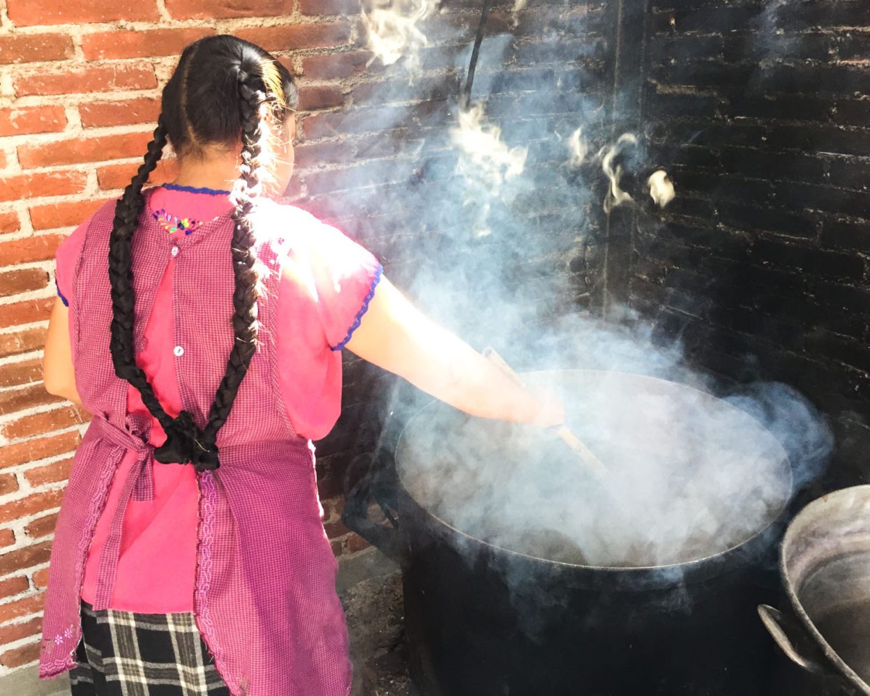 María stirs yarn in a boiling pot of natural dyes until the color sets. natural dyes oaxaca