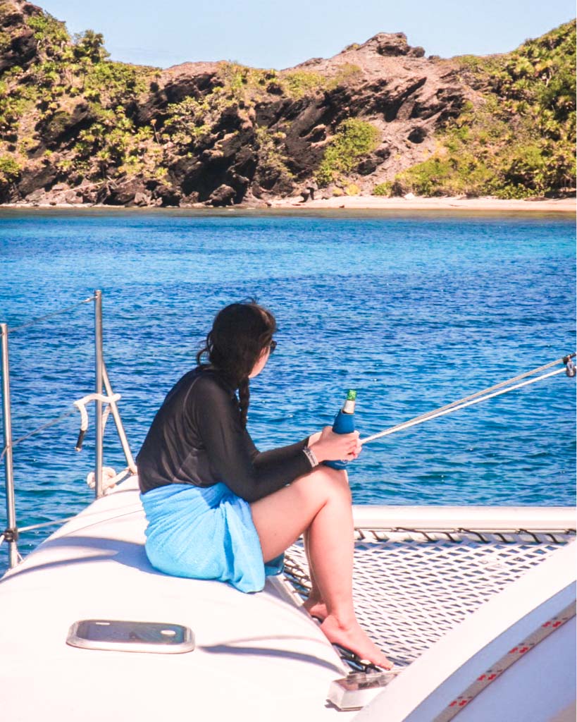 enjoying a beer on the cayos cochinos from roatan tour