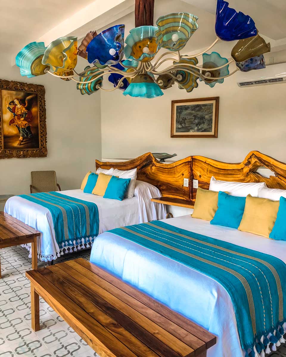 bedroom suite with two queen beds and artisan made chandelier in mexico vacation rental
